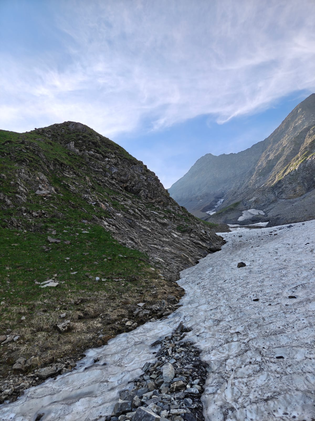 Narrow gully with a snow patch leading up toward a rocky ridge
