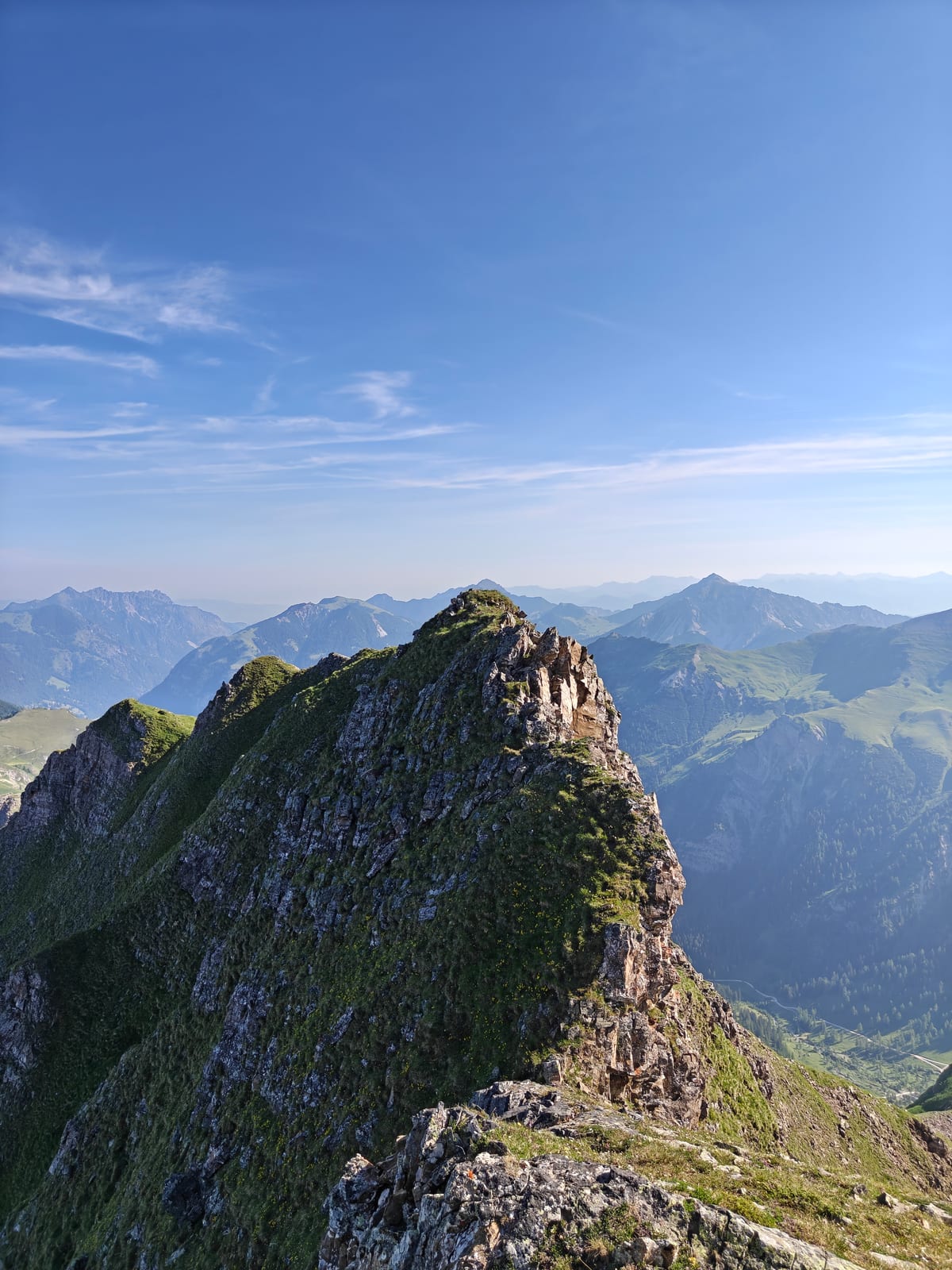 Rocky ridge with snow patches, view along the crest toward distant peaks