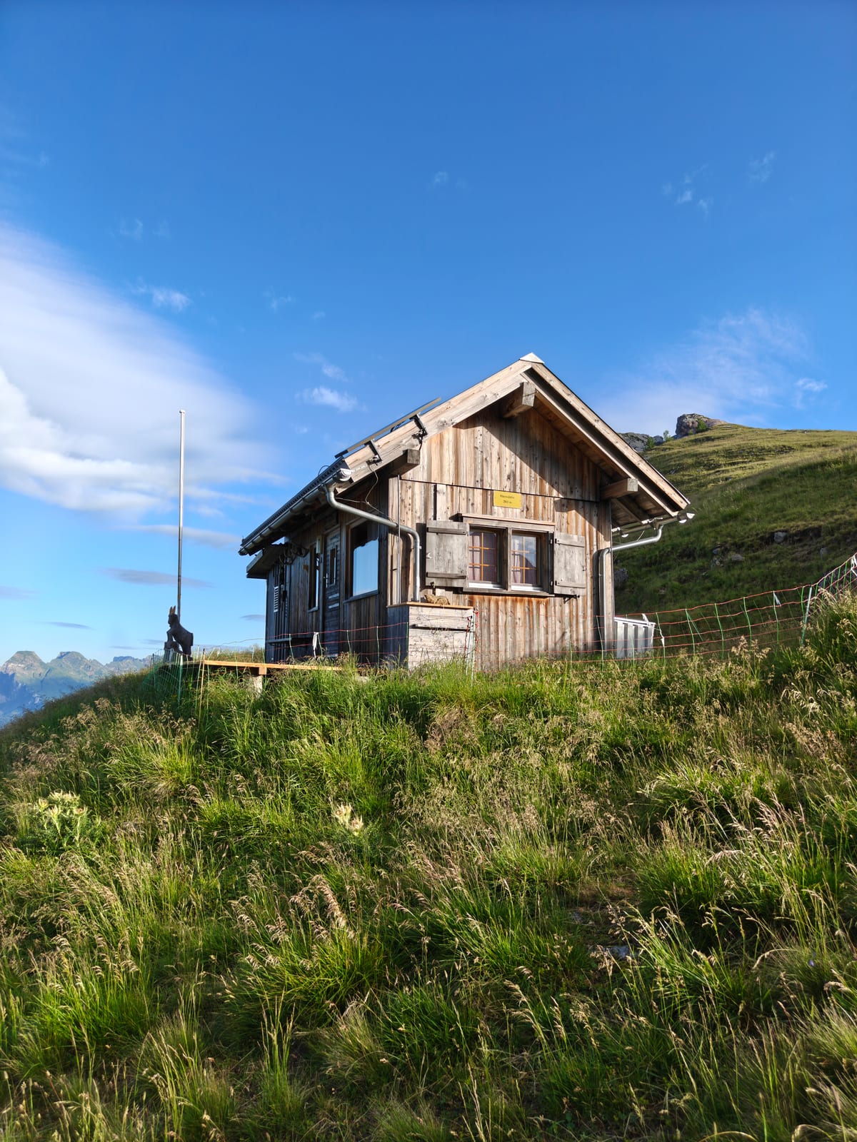 Small wooden alpine hut on the Guschasattel with mountains behind