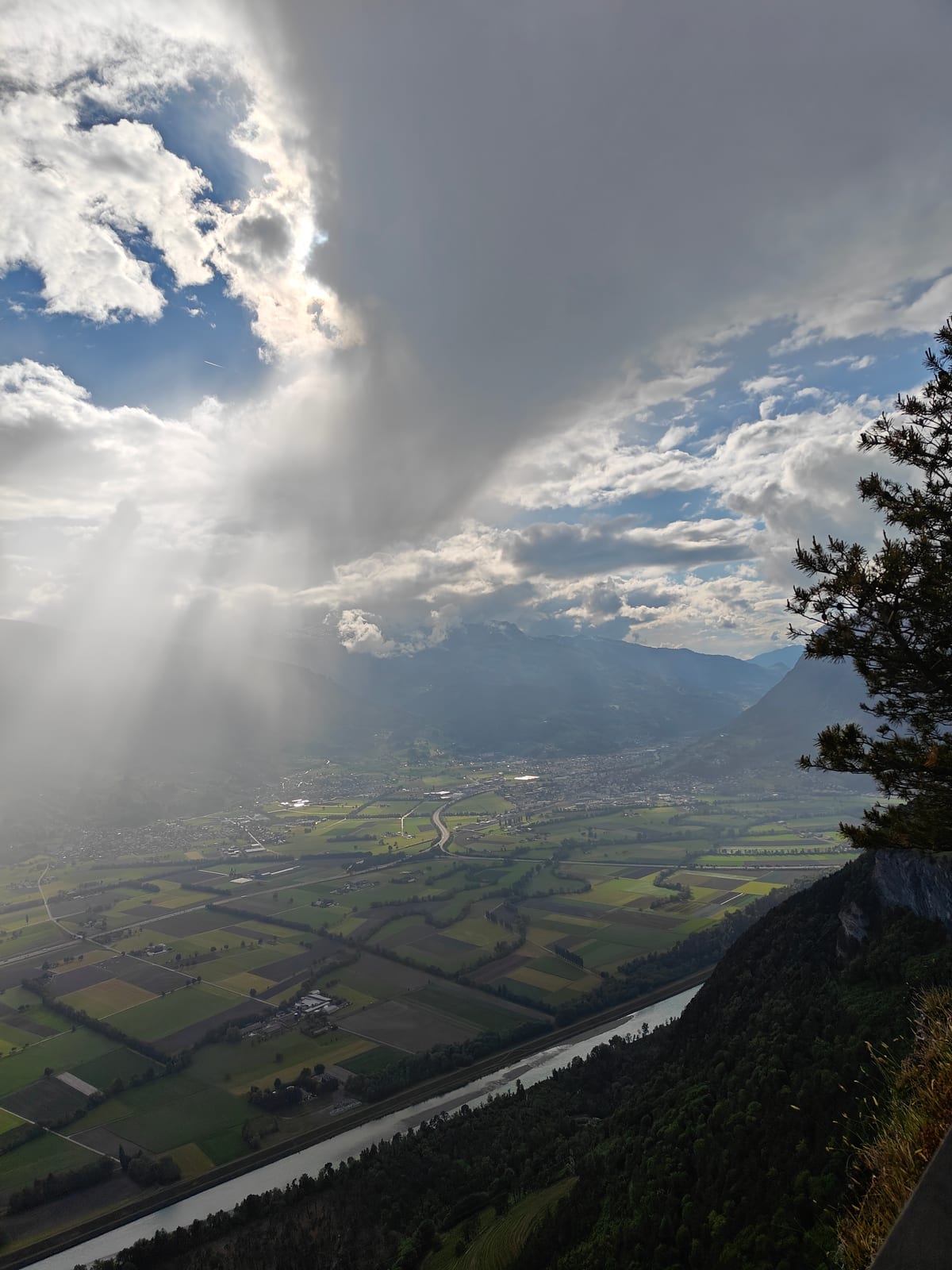 Dramatic view over Rhine Valley with storm light and steep cliff edge visible