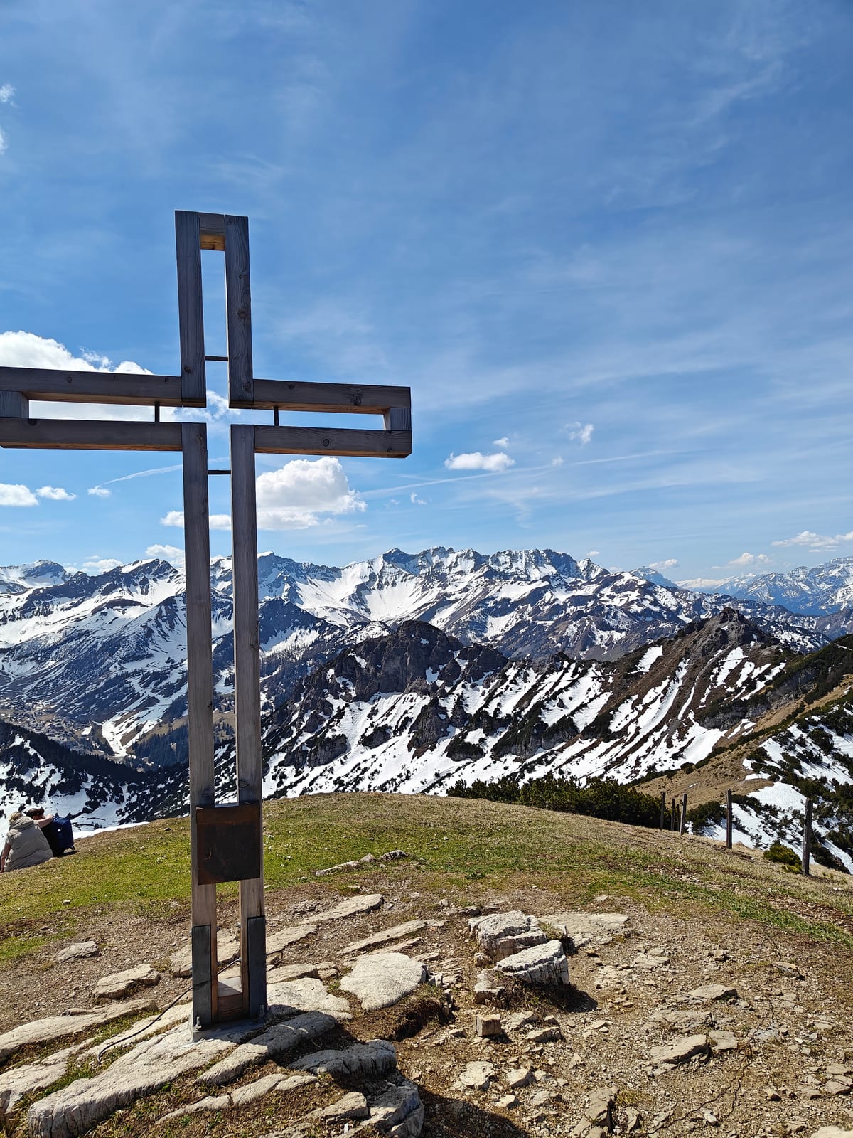 Summit cross on Schönberg with snow-covered Alps panorama